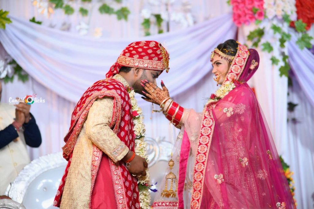 A joyful Indian wedding moment in Gorakhpur, captured by Candid Clicks, showing the bride gently feeding the groom during the ceremony.